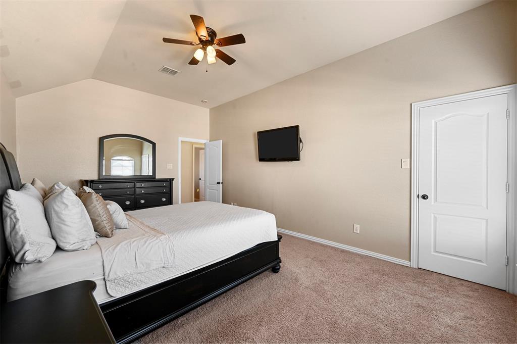 14815 Frisco Ranch Drive Little Elm, TX 75068 - Photo 27 of 40 a bedroom with a bed and a chandelier
