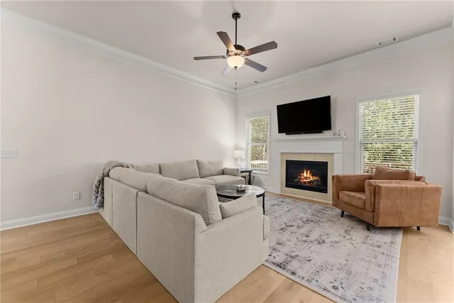 a kitchen with stainless steel appliances granite countertop a kitchen island a stove a refrigerator a sink a dining table and chairs with wooden floor