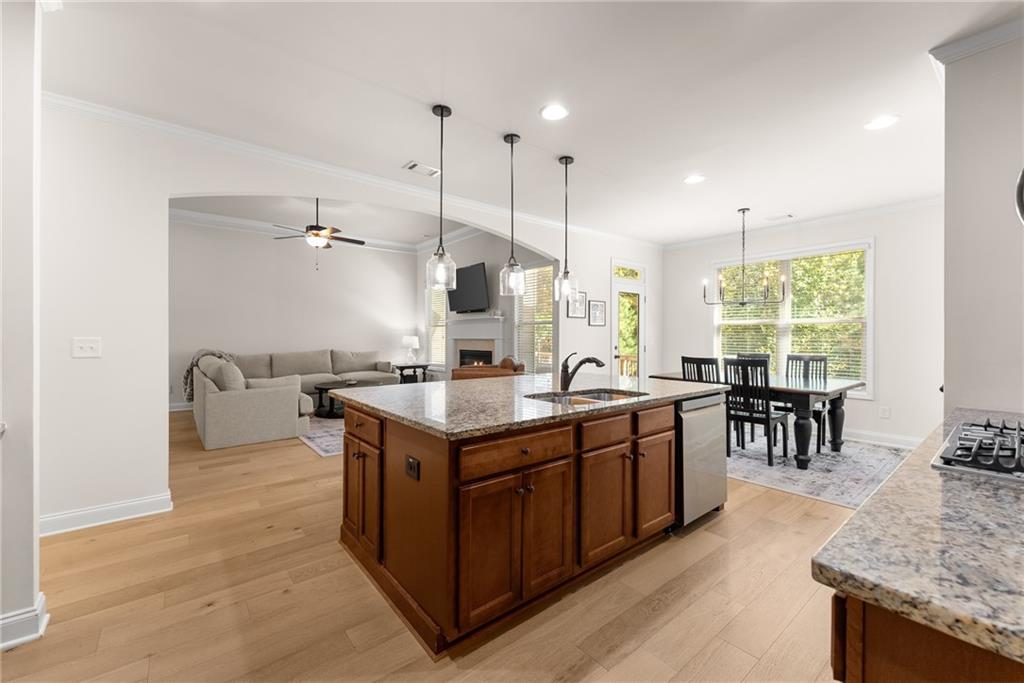 8055 Veranda Curve Ball Ground, GA 30107 - Photo 19 of 65 a kitchen with kitchen island a sink stove and wooden cabinets