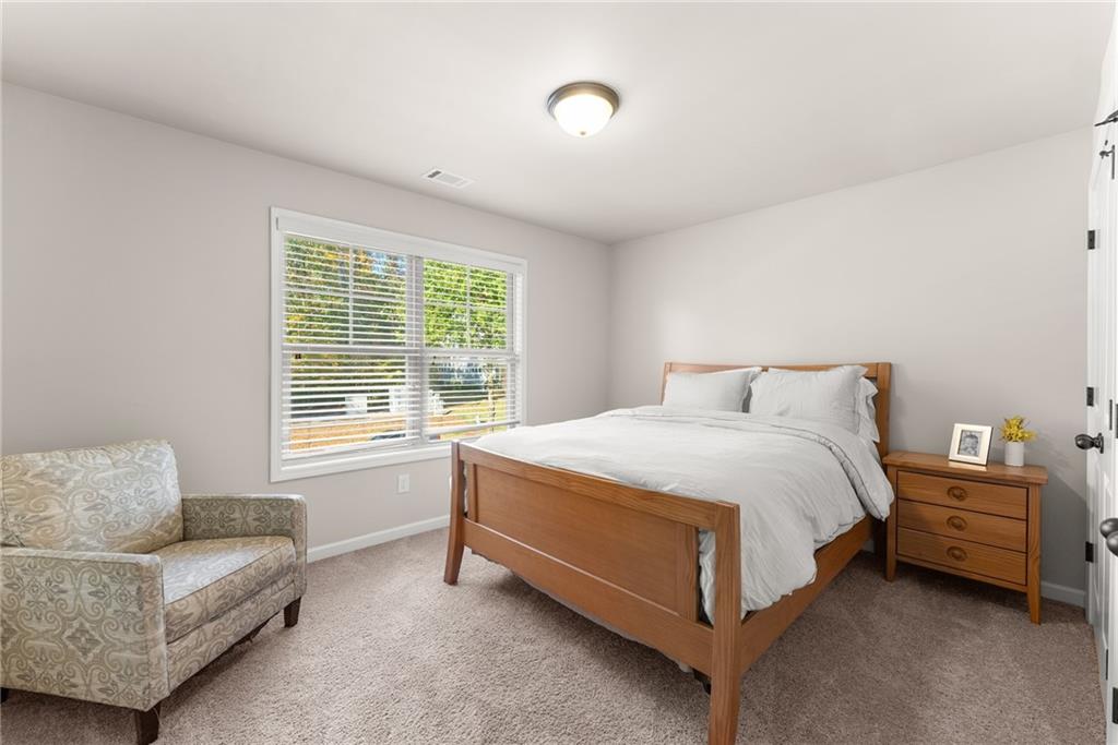 8055 Veranda Curve Ball Ground, GA 30107 - Photo 37 of 65 a spacious bedroom with a bed and a couch