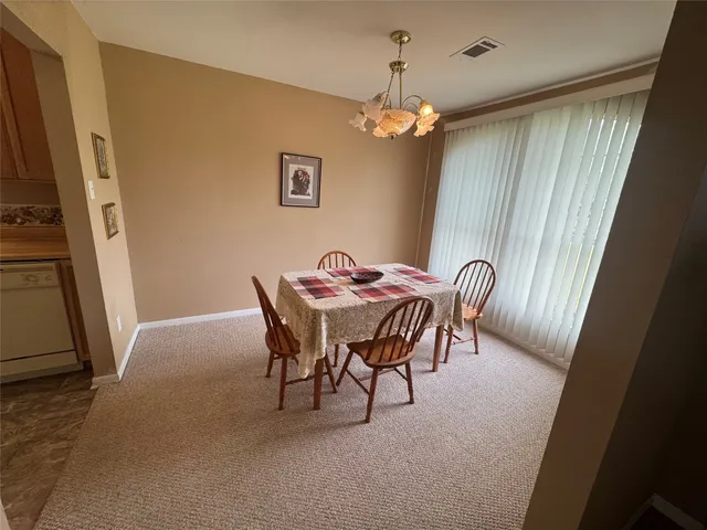 a view of a dining room with furniture and chandelier