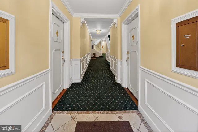 a view of a hallway with wooden floor and staircase