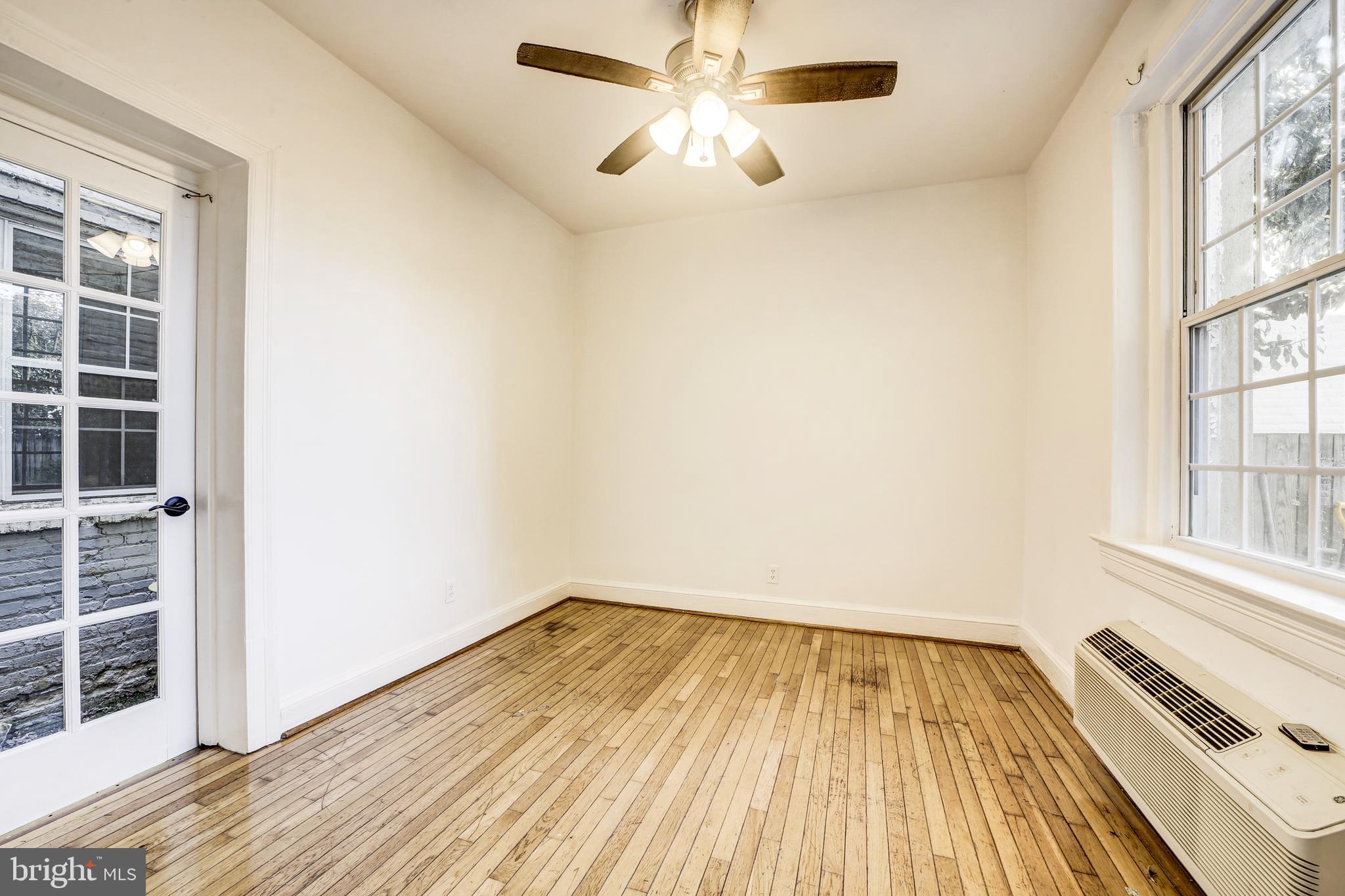 3520 W Place Northwest, Unit 103 Washington, DC 20007 - Photo 6 of 13 a view of empty room with wooden floor and fan