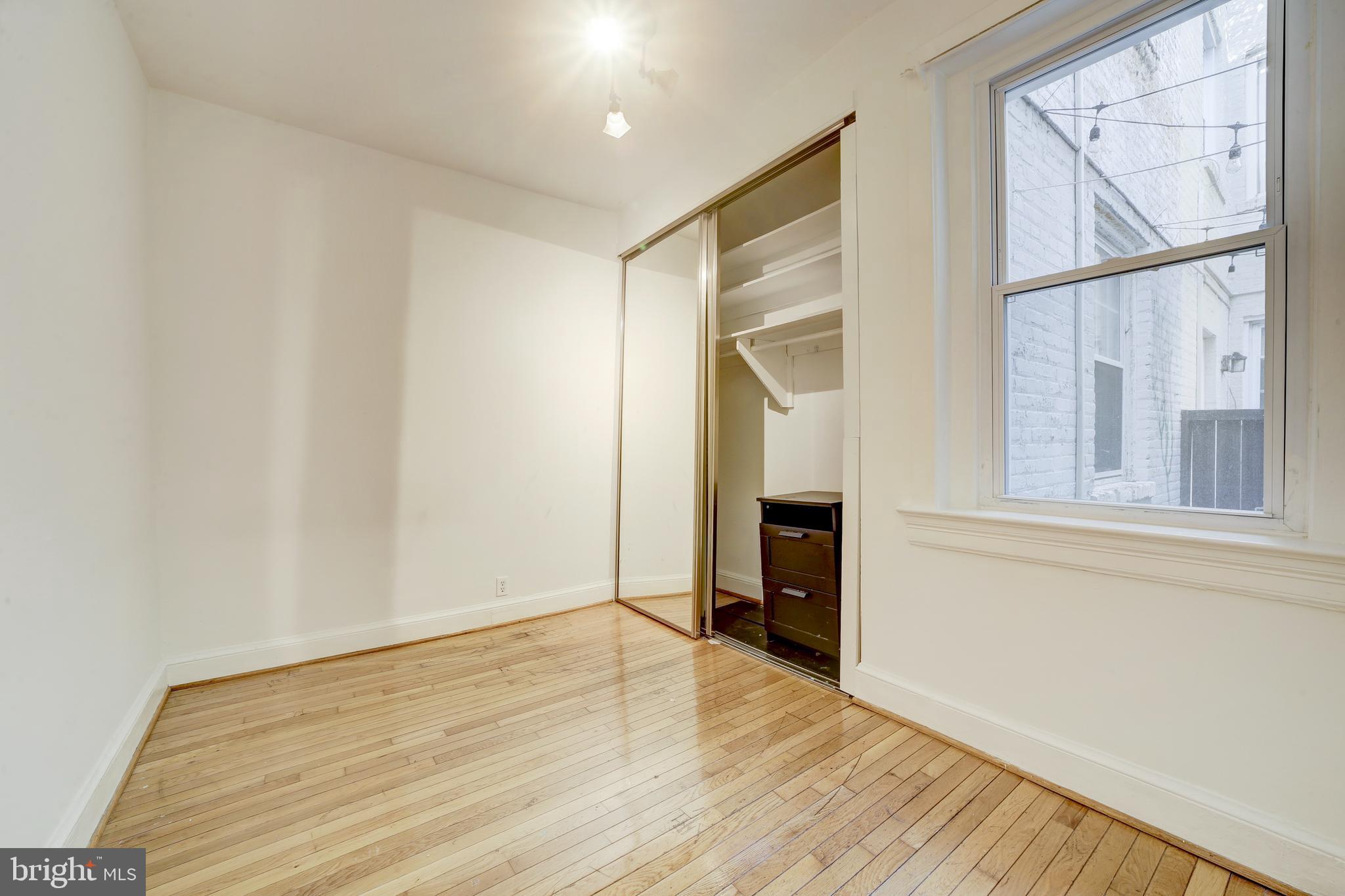 3520 W Place Northwest, Unit 103 Washington, DC 20007 - Photo 9 of 13 a view of empty room with wooden floor and fan