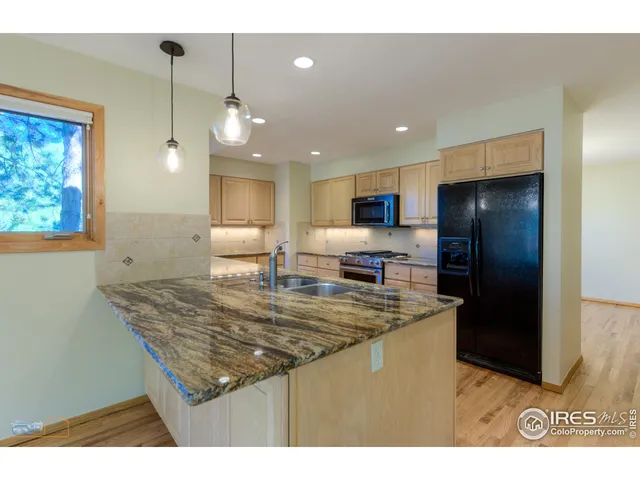 a kitchen with kitchen island stainless steel appliances a sink stove and refrigerator
