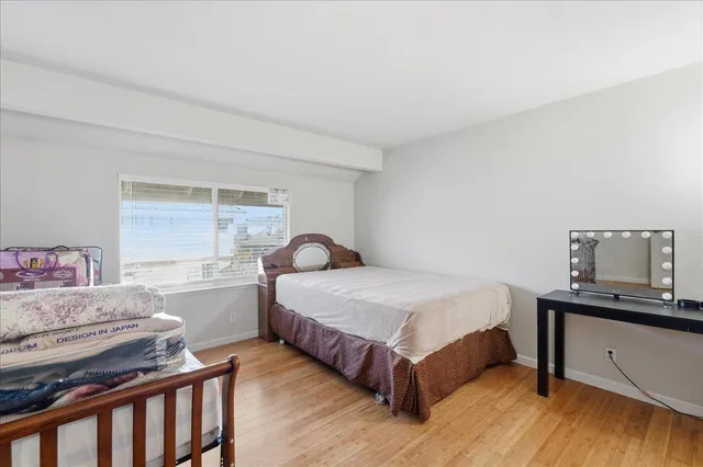 a bedroom with a bed and wooden floor