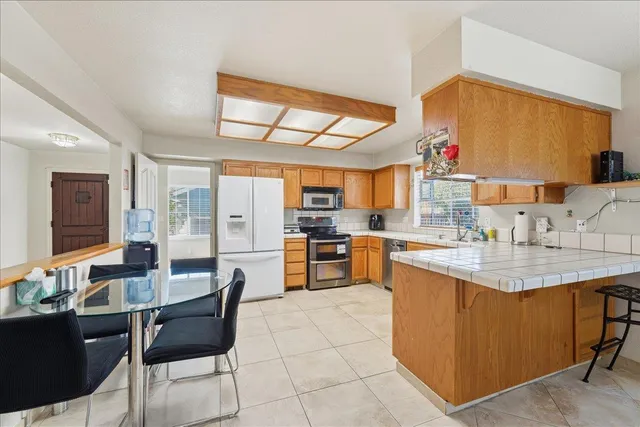 a kitchen with stainless steel appliances kitchen island granite countertop a sink and cabinets