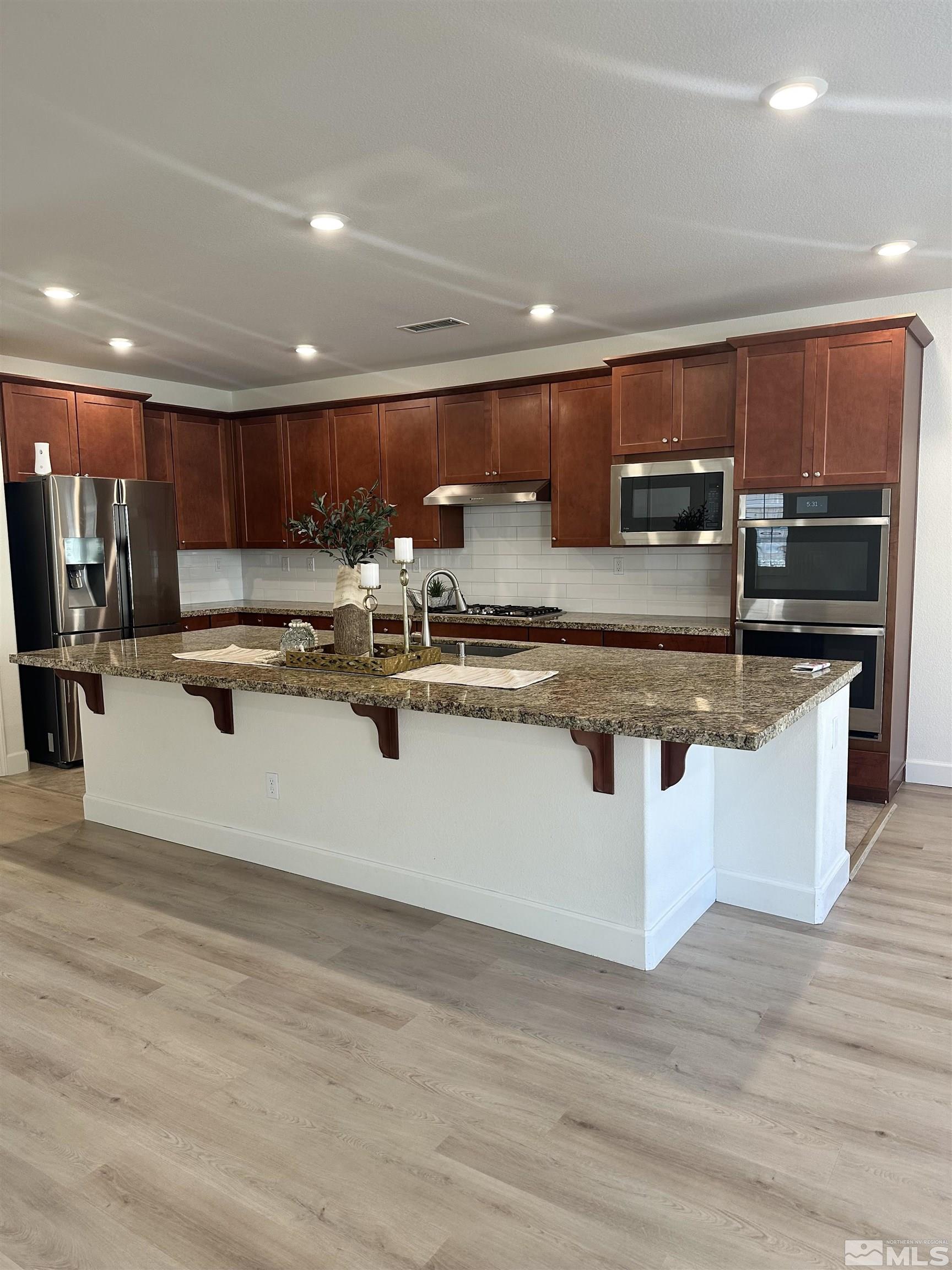 10310 Alchemy Way Reno, NV 89521 - Photo 11 of 30 a kitchen with stainless steel appliances granite countertop a sink counter space and cabinets