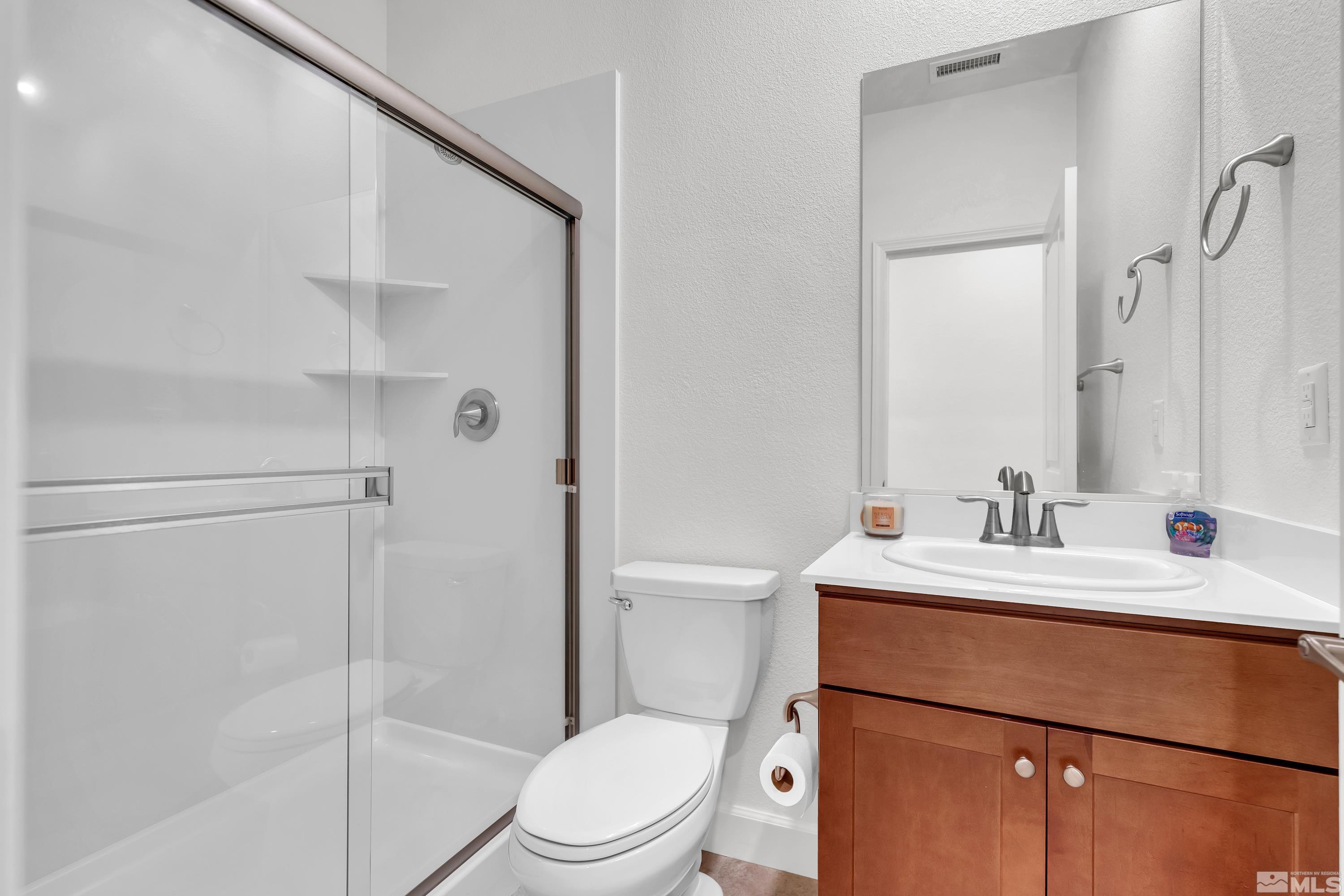 10310 Alchemy Way Reno, NV 89521 - Photo 21 of 30 a bathroom with a sink toilet vanity and shower