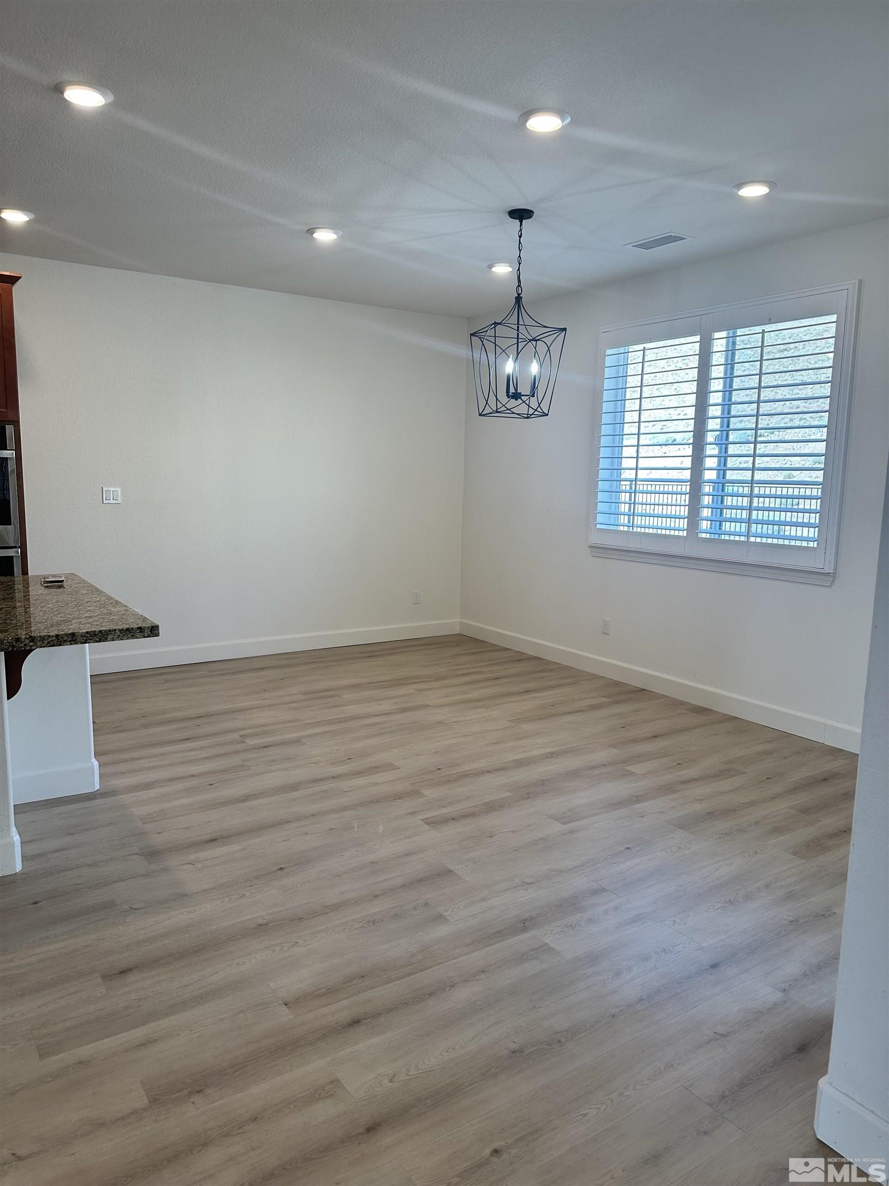 10310 Alchemy Way Reno, NV 89521 - Photo 6 of 30 an empty room with wooden floor and windows