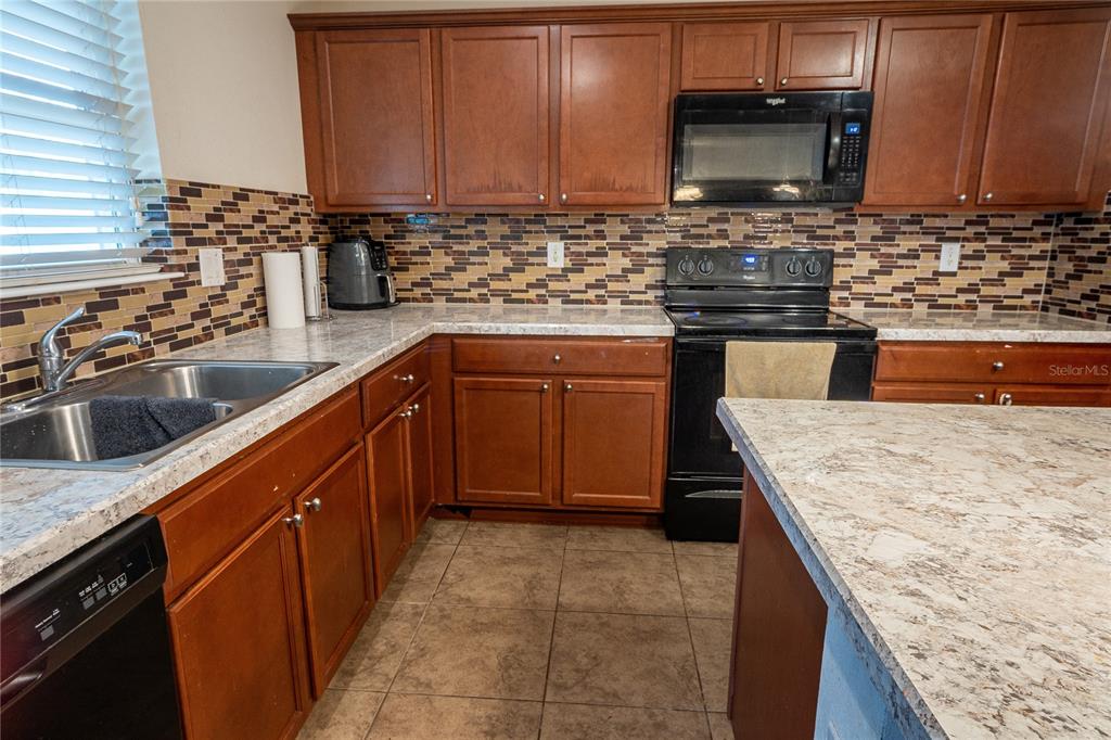 4563 Orchard Grove Road St. Cloud, FL 34772 - Photo 39 of 51 a kitchen with stainless steel appliances granite countertop a sink stove and microwave