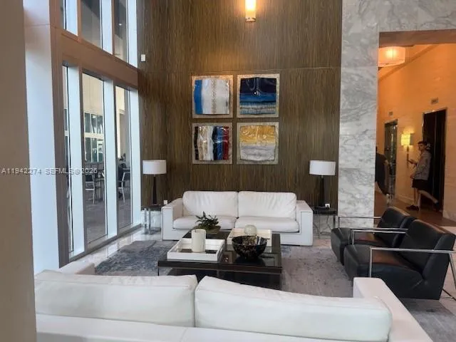 a living room with furniture and large windows