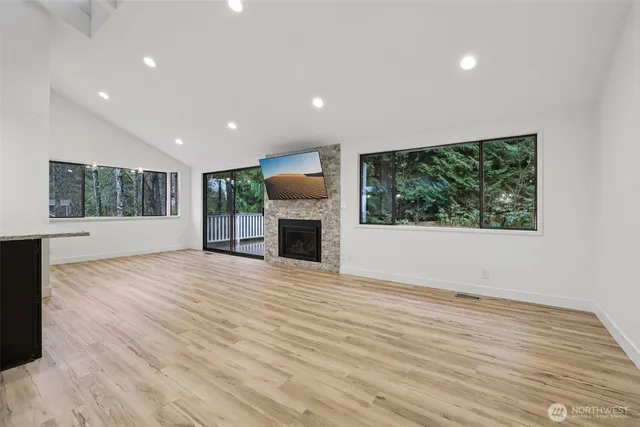 a view of empty room with wooden floor and fireplace