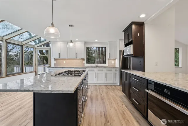 a kitchen with granite countertop a sink appliances and cabinets
