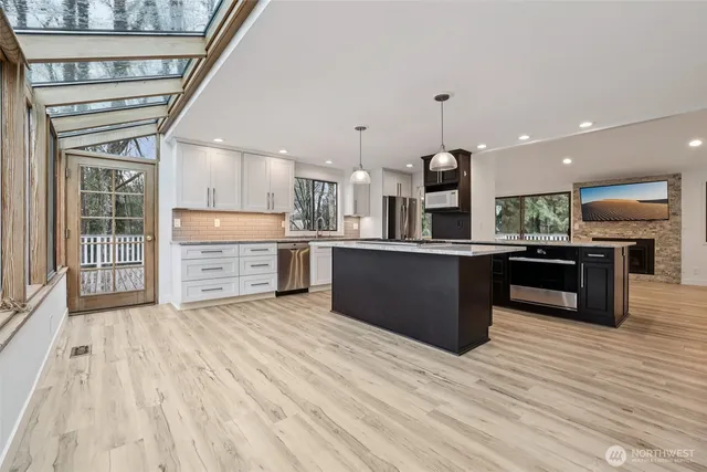 a kitchen with stainless steel appliances kitchen island granite countertop a stove top oven and sink
