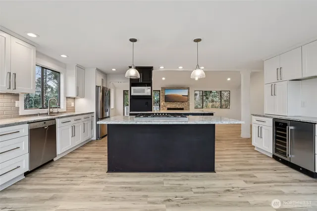 a kitchen with stainless steel appliances granite countertop a stove a sink and a refrigerator