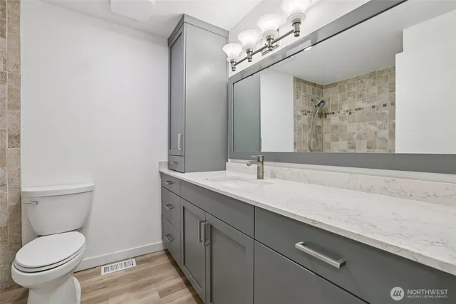 a bathroom with a toilet a sink and mirror