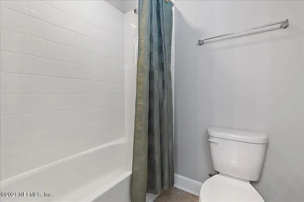 a white toilet sitting next to a bath tub