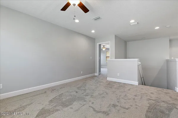 an empty room with ceiling fan and window