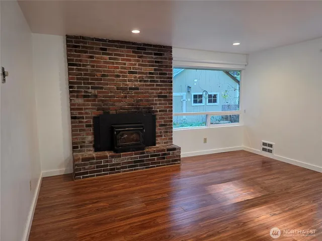 an empty room with wooden floor and fireplace