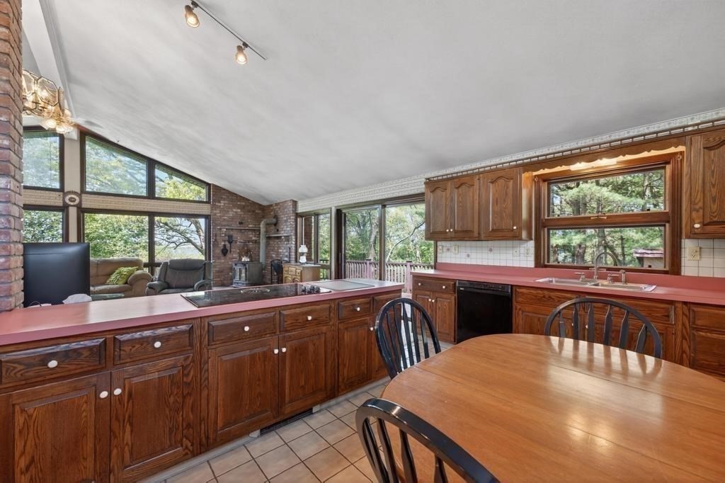 38 Gaudette Street Fall River, MA 02721 - Photo 31 of 41 a kitchen with stainless steel appliances granite countertop a stove a sink dishwasher a dining table and with wooden cabinets next to a large window