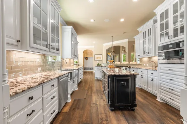 a kitchen with stainless steel appliances granite countertop a stove and cabinets