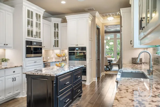 a kitchen with stainless steel appliances granite countertop a sink stove and cabinets