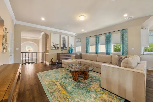 a living room with furniture and a wooden floor