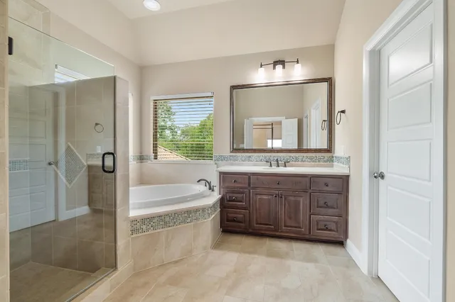 a bathroom with a granite countertop sink a mirror and a bathtub