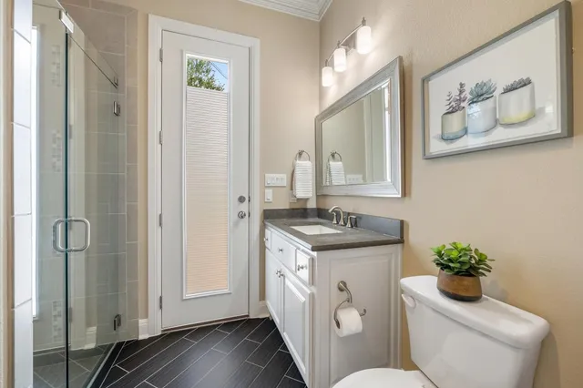 a bathroom with a granite countertop toilet a sink and mirror