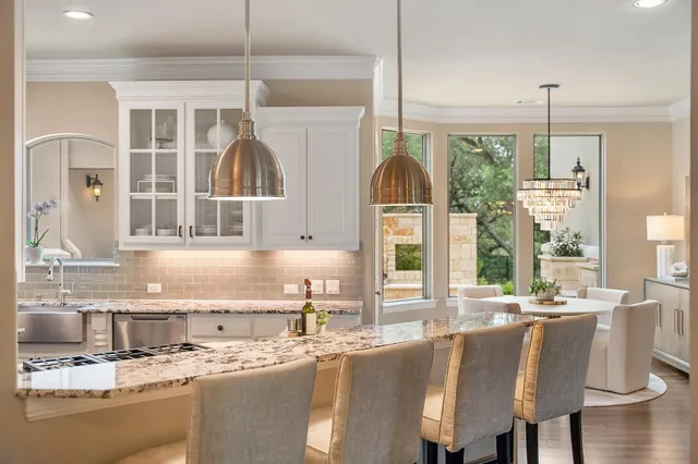 a kitchen with stainless steel appliances granite countertop a sink a microwave counter and a cabinets