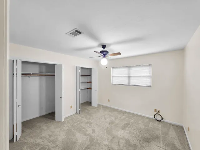 an empty room with closet and windows