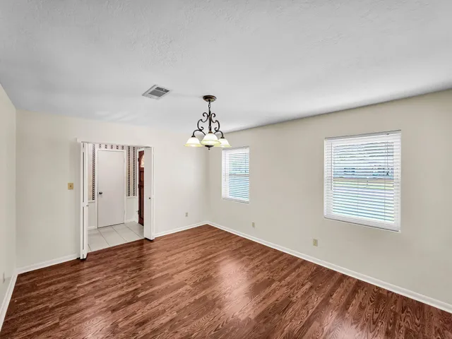 a view of a room with wooden floor and chandelier