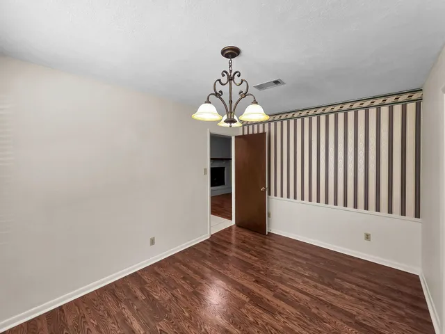 a view of a room with wooden floor staircase and a kitchen space