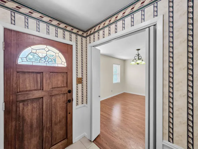 a view of a hallway with entryway wooden floor and front door