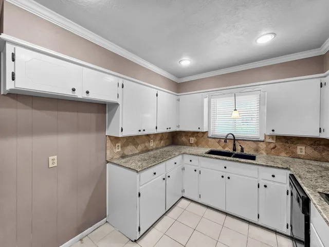 a kitchen with granite countertop white cabinets and stainless steel appliances