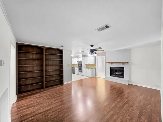 a view of an empty room with a fireplace and a window