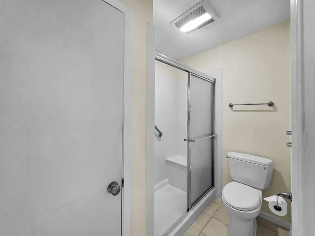 a white toilet sitting next to a bathroom sink and a shower