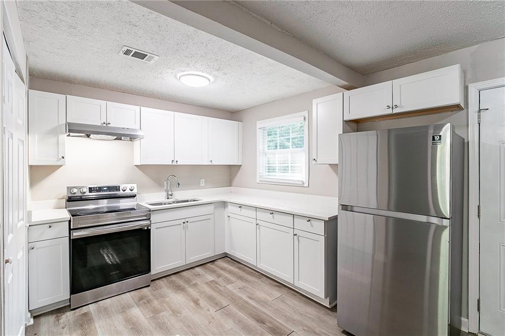 1669 Freedom Valley Decatur, GA 30032 - Photo 7 of 27 a kitchen with a stove sink and refrigerator