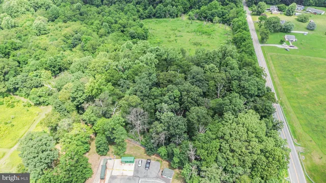 an aerial view of residential houses with outdoor space and trees