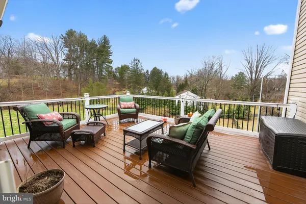 a roof deck with couches and wooden floor