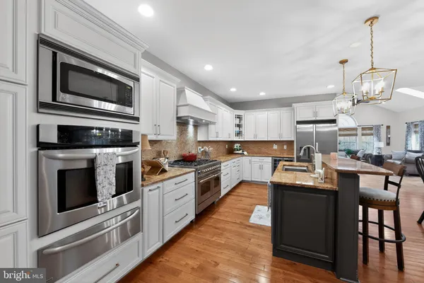 a large kitchen with stainless steel appliances granite countertop a stove and a sink