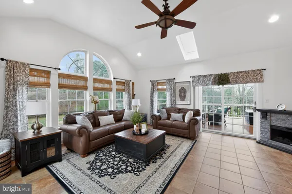 a living room with furniture large windows and a fireplace