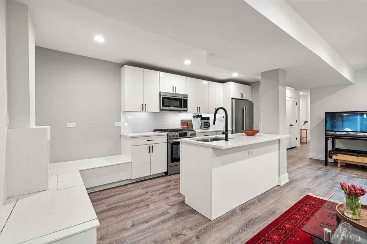 3432 West Belden Avenue, Unit G Chicago, IL 60647 - Photo 12 of 32 a kitchen with microwave a stove and cabinets
