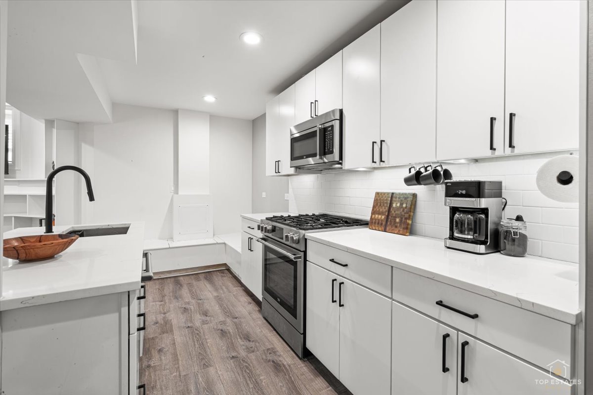 3432 West Belden Avenue, Unit G Chicago, IL 60647 - Photo 16 of 32 a kitchen with a sink a stove and cabinets