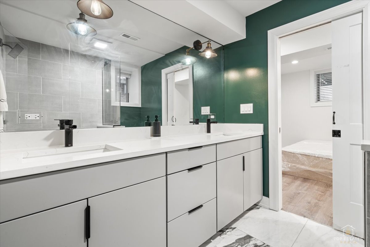 3432 West Belden Avenue, Unit G Chicago, IL 60647 - Photo 25 of 32 a bathroom with a double vanity sink a mirror and shower