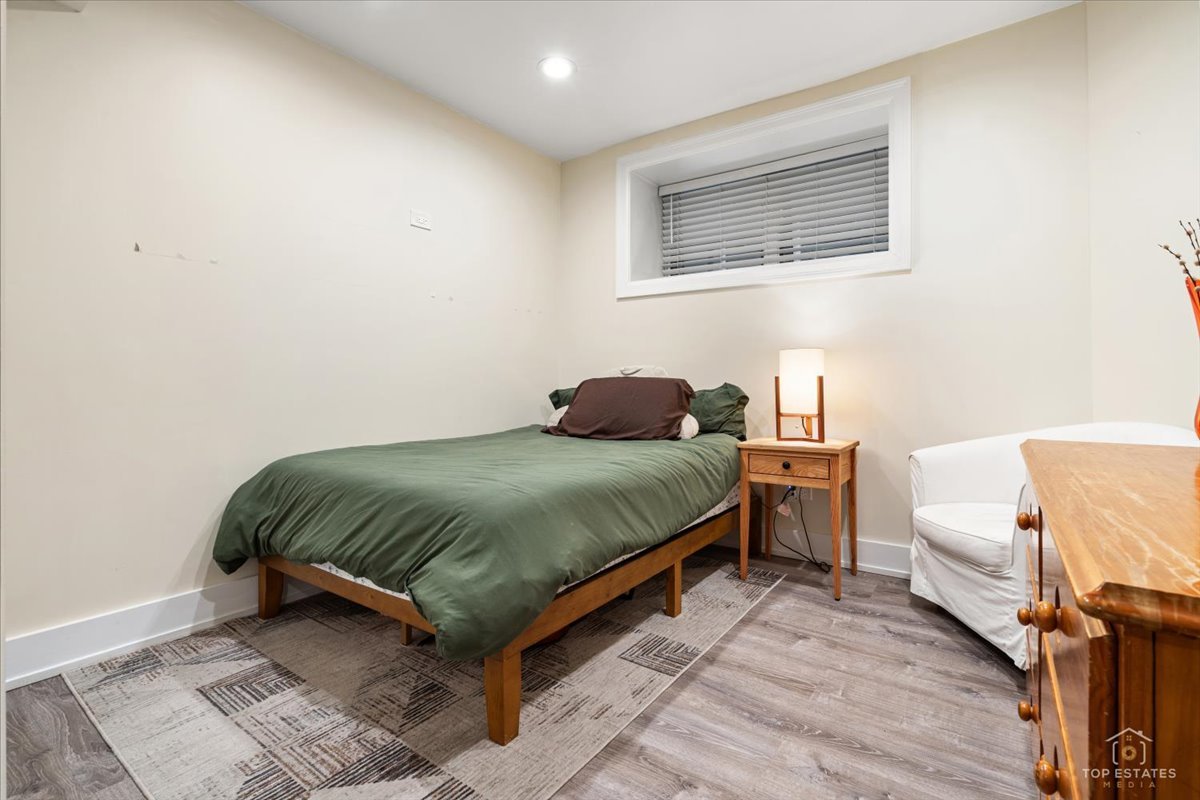 3432 West Belden Avenue, Unit G Chicago, IL 60647 - Photo 26 of 32 a bedroom with a bed and wooden floor