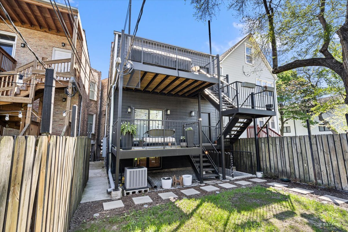 3432 West Belden Avenue, Unit G Chicago, IL 60647 - Photo 32 of 32 a view of patio with a table and chairs under an umbrella with wooden fence