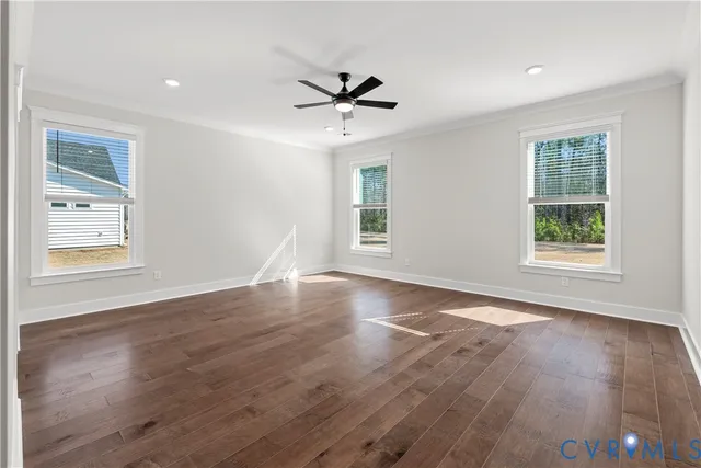 a view of a livingroom with wooden floor window and a ceiling fan