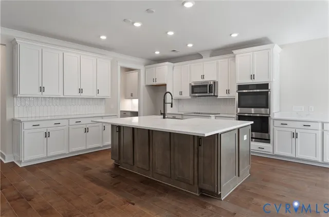 a kitchen with kitchen island granite countertop white cabinets white stainless steel appliances and sink